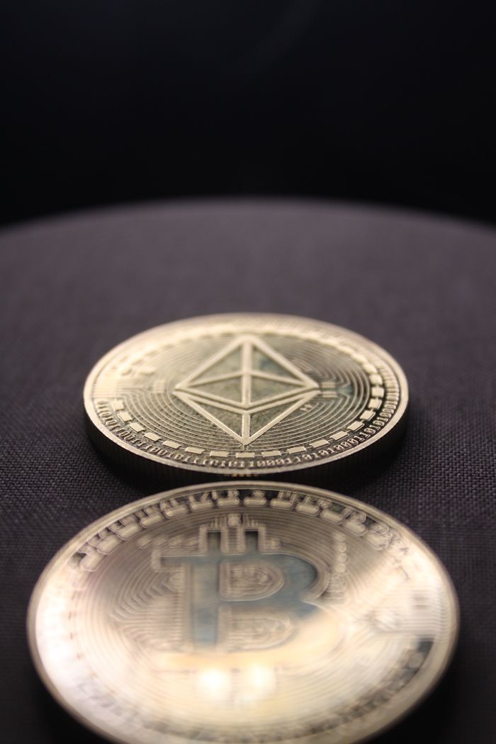 Detailed shot of Bitcoin and Ethereum coins on a dark surface.